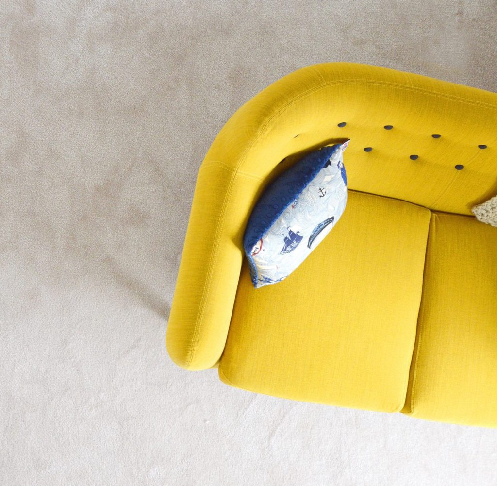 a yellow couch with blue pillows
