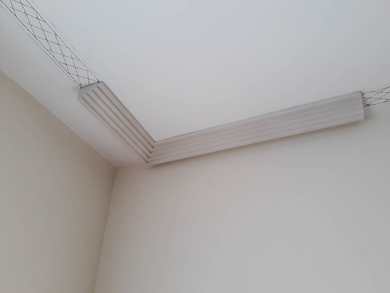 a white ceiling with a mesh on the corner