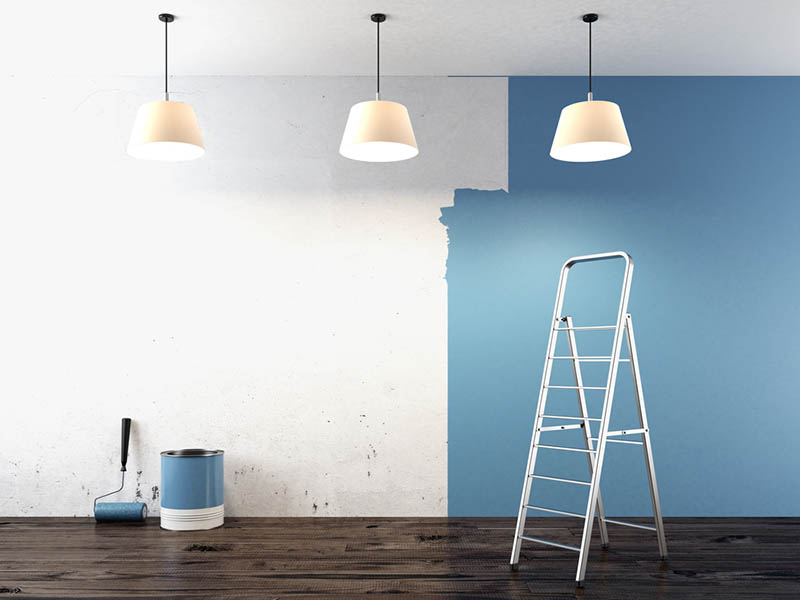 Painting a room with blue walls and a ladder.