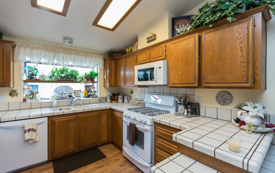 a kitchen with white tile counter tops and cabinets