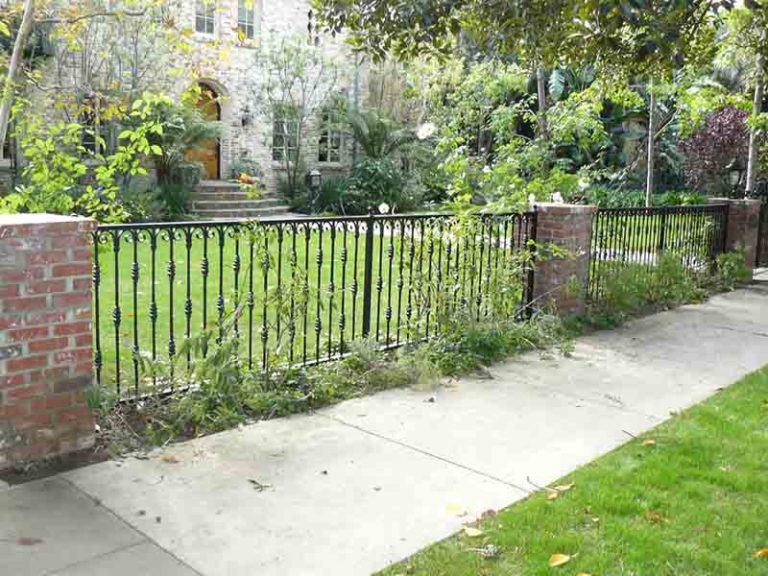 a fence and sidewalk in front of a house
