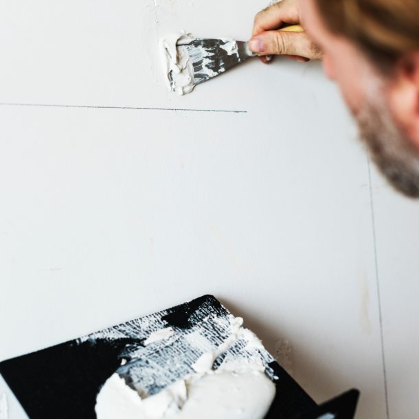 a person using a spatula to put a line on a wall